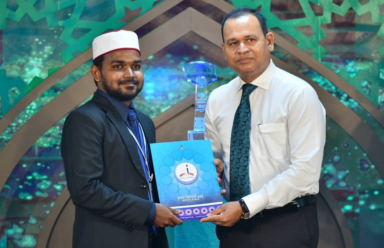 ރާއްޖޭގައި ބޭއްވި ބައިނަލްއަގުވާމީީ ގުރުއާން މުބާރާތުން 3ވަނަ ހޯދި ރާއްޖޭގެ ބައިވެރިއާ އަޝްރަގަށް. ޑިފެންސް މިނިސްޓަރު އާދަމް ޝަރީފް (ކ) ސެޓްފިކެޓް ހަވާލުކޮށްދެއްވަނީ.--ފޮޓޯ: ހުސެއިން ވަހީދު/ މިހާރު