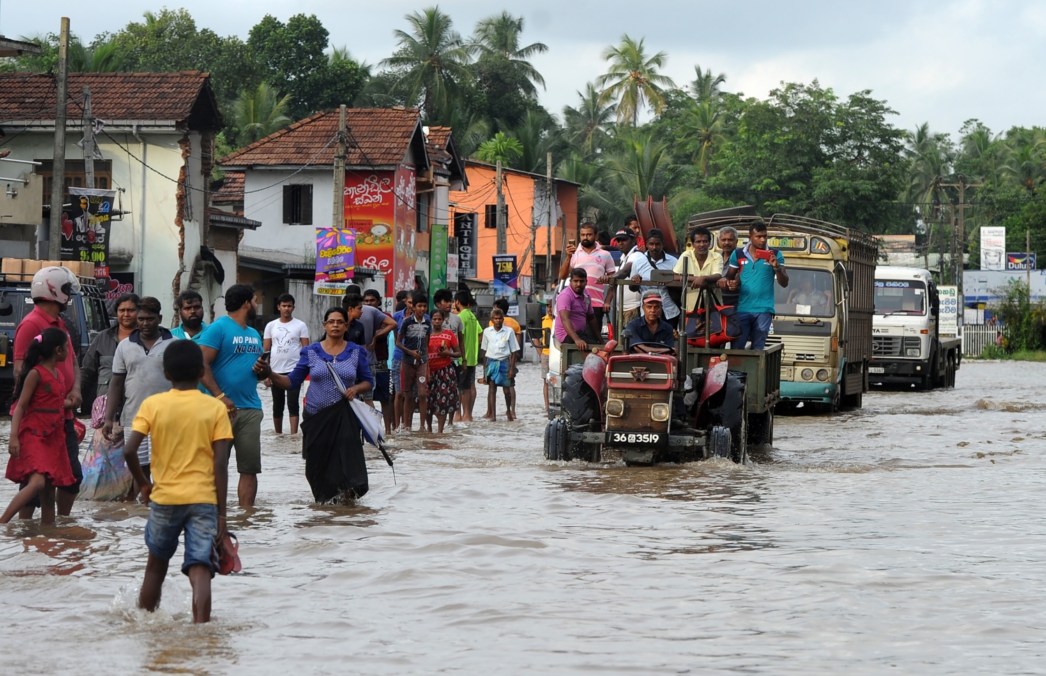 ވެރިރަށް ކޮލަމްބޯގެ ކަޑުވެލައިގައި ފެންބޮޑުވެފައިވާ ސަރަހައްދަކުން ބަޔަކު ހިނގާފައި ދަނީ. --ފޮޓޯ:އޭއެފްޕީ