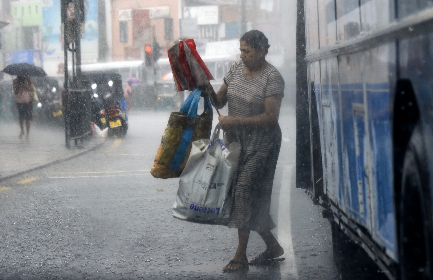 ވެރިރަށް ކޮލަމްބޯ އަށް ބޯކޮށް ވާރޭ ވެހެމުންދިޔަ އިރު އަންހެނަކު ކުޑަ ނަގައިގެން ބޭރަށް ނުކުންނަނީ. --ފޮޓޯ:އޭއެފްޕީ