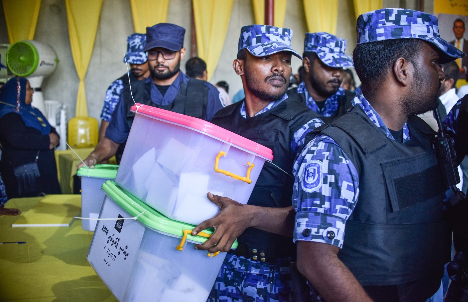 އެމްޑީޕީ ހަރުގޭގައި ހުރި ފޮށިތައް ހިފައިގެން ފުލުހުން ނިކުންނަނީ. ފުލުހުން އޭރު ވޯޓު ފޮށިތައް ގެންދިޔަ ނަމަވެސް، ވޯޓުލުން ރާއްޖޭގެ އެކިކަންކޮޅުތަކުގައި ކުރިއަށް ދިޔަ. - ފޮޓޯ: ނިޝާން އަލީ | މިހާރު