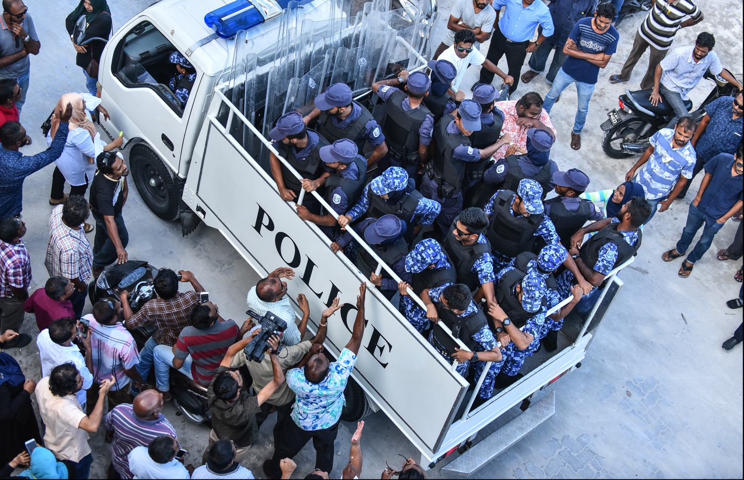 އެމްޑީޕީގެ މުޒާހަރާއެއް ހުއްޓުވަން ހަރަކާތްތެރިވި ފުލުހުންތަކެއް ވެހިކަލެއްގައި. --ފޮޓޯ: ހުސެއިން ވަހީދު/ މިހާރު