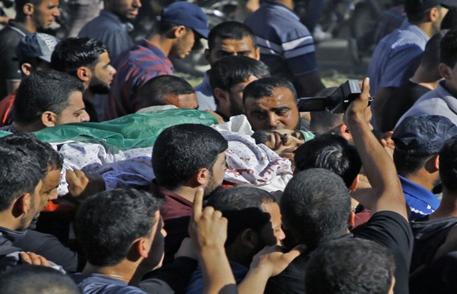 އިޒްރޭލުގެ އަޅުވެތިކަމާ ދެކޮޅަށް ފަލަސްތީނު ރައްޔިތުން ފަށައިގެން މިހާރު ކުރަމުންދާ ސިލްސިލާ މުޒާހަރާތައް ހުއްޓުވުމަށް އިޒްރޭލު ސިފައިން ދިން ހަމަލާތަކުގައި ޝަހީދުވި ފަލަސްތީނު މީހެއްގެ ޖަނާޒާ ބާއްވަނީ. --ފޮޓޯ އަލްޖަޒީރާ