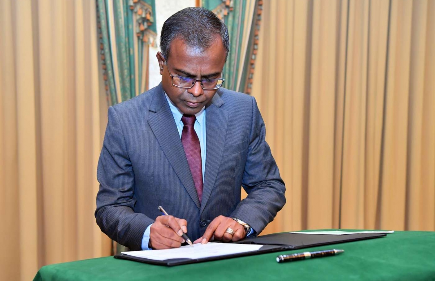 މާލެ: ޖޫން 28، 2018: އުއްތަމަ ފަނޑިޔާރު ކަމަށް އައްޔަން ކުރެއްވި ޑރ. އަހުމަދު އަބްދުﷲ ދީދީ މަގާމުގެ ފަތްކޮޅުގައި ސޮއި ކުރައްވަނީ.-- ފޮޓޯ: ރައީސް އޮފީސް