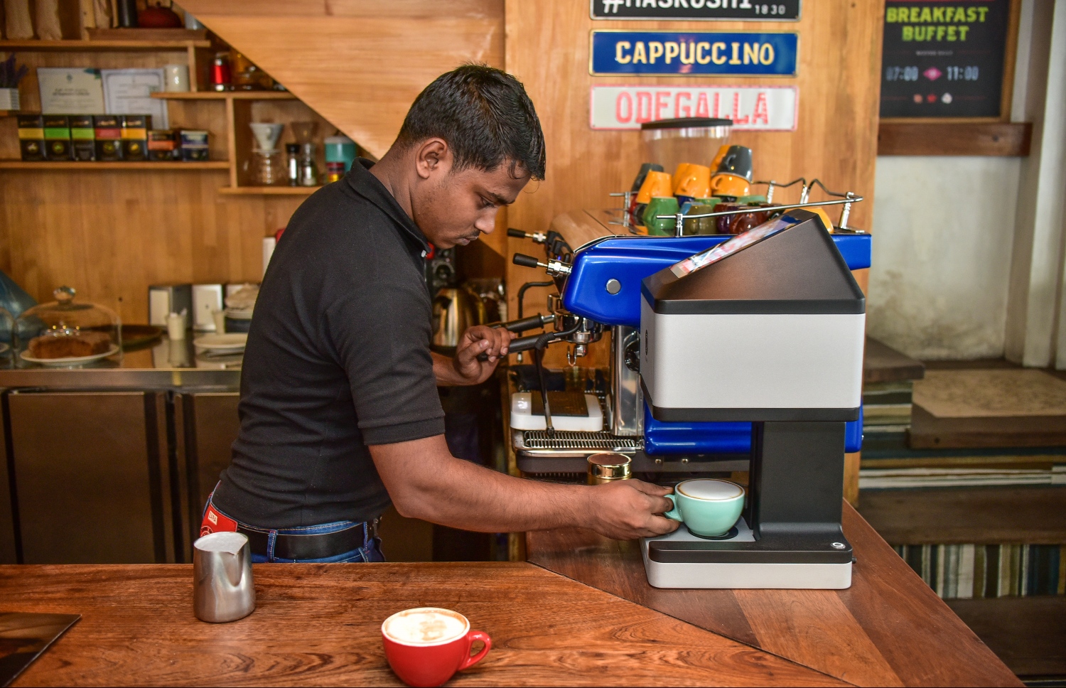 އޮޑެގައްލާ އިން ރާއްޖެ އަށް ތައާރަފުކުރި، "ރަ ރިޕްލްސް އިފެކްޓް" ގެ ޓެކްނޮލޮޖީގެ އެހީގައި ކޮފީތައްޓެއްގެ މައްޗަށް ސްޓިކާއެއް ޕްރިންޓް ކުރަނީ.---ފޮޓޯ: ނިޝާން އަލީ/މިހާރު