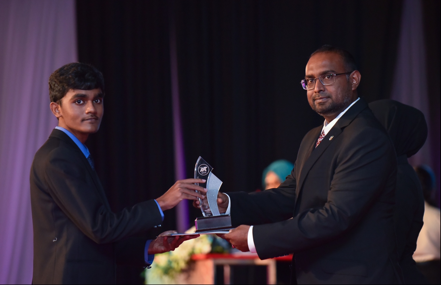 މާލެ: ޖުލައި 9، 2018: މިދިޔަ އަހަރުގެ އޮކްޓޯބަރު/ނޮވެމްބަރުގައި ބޭއްވި އޭ ލެވެލް އިމްތިހާނުން ވަނަތައް ހޯދި ދަރިވަރުންނަށް އެވޯޑު ދިނުމުގެގޮތުން ދަރުބާރުގޭގައި ބޭއްވި ރަސްމިއްޔާތުގައި، ރައީސް އޮފީހުގެ ސްޓޭޓް މިނިސްޓަރު މުޖުތާޒް، ދަރިވަރަކަށް އެވޯޑު ހަވާލުކުރައްވަނީ.--- ފޮޓޯ: ހުސައިން ވަހީދު/މިހާރު