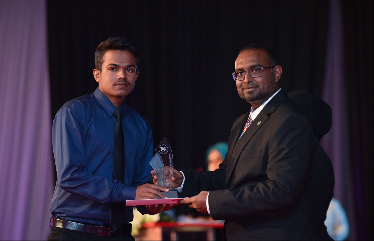 މާލެ: ޖުލައި 9، 2018: މިދިޔަ އަހަރުގެ އޮކްޓޯބަރު/ނޮވެމްބަރުގައި ބޭއްވި އޭ ލެވެލް އިމްތިހާނުން ވަނަތައް ހޯދި ދަރިވަރުންނަށް އެވޯޑު ދިނުމުގެގޮތުން ދަރުބާރުގޭގައި ބޭއްވި ރަސްމިއްޔާތުގައި، ރައީސް އޮފީހުގެ ސްޓޭޓް މިނިސްޓަރު މުޖުތާޒް، ދަރިވަރަކަށް އެވޯޑު ހަވާލުކުރައްވަނީ.--- ފޮޓޯ: ހުސައިން ވަހީދު/މިހާރު