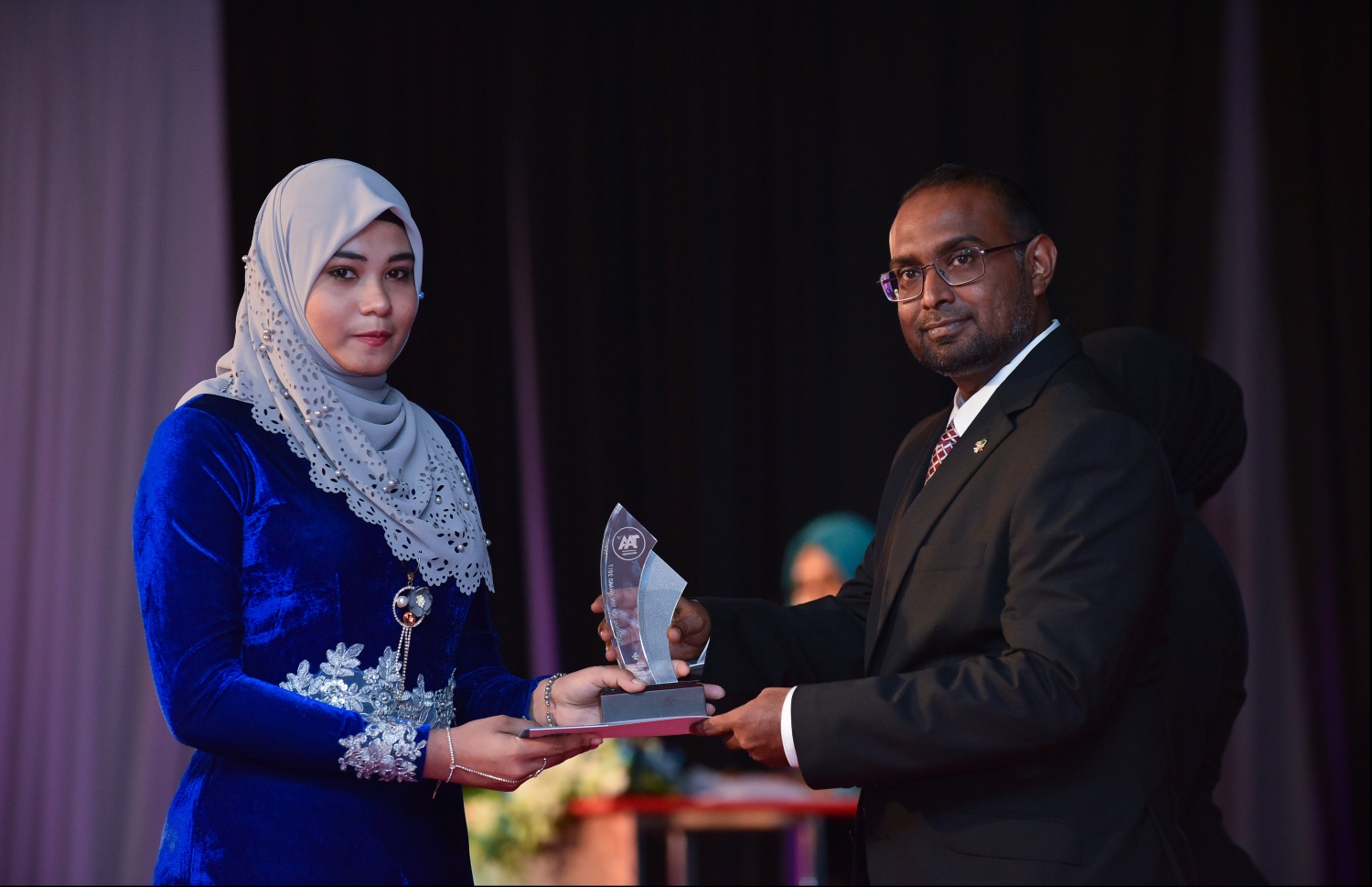 މާލެ: ޖުލައި 9، 2018: މިދިޔަ އަހަރުގެ އޮކްޓޯބަރު/ނޮވެމްބަރުގައި ބޭއްވި އޭ ލެވެލް އިމްތިހާނުން ވަނަތައް ހޯދި ދަރިވަރުންނަށް އެވޯޑު ދިނުމުގެގޮތުން ދަރުބާރުގޭގައި ބޭއްވި ރަސްމިއްޔާތުގައި، ރައީސް އޮފީހުގެ ސްޓޭޓް މިނިސްޓަރު މުޖުތާޒް، ދަރިވަރަކަށް އެވޯޑު ހަވާލުކުރައްވަނީ.--- ފޮޓޯ: ހުސައިން ވަހީދު/މިހާރު