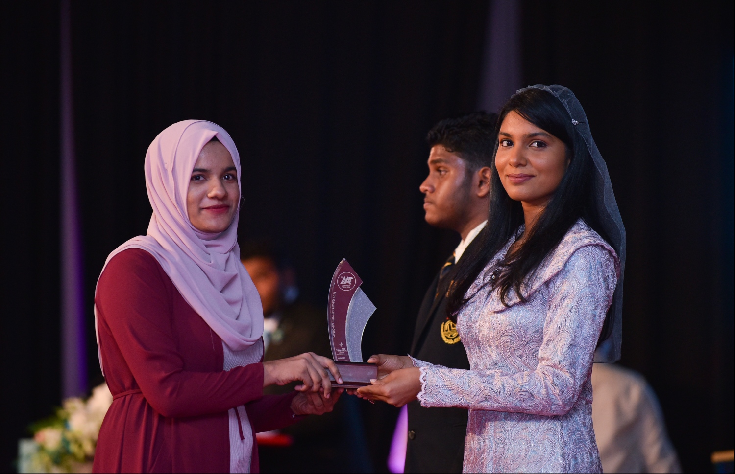 މާލެ: ޖުލައި 9، 2018: މިދިޔަ އަހަރުގެ އޮކްޓޯބަރު/ނޮވެމްބަރުގައި ބޭއްވި އޭ ލެވެލް އިމްތިހާނުން ވަނަތައް ހޯދި ދަރިވަރުންނަށް އެވޯޑު ދިނުމުގެގޮތުން ދަރުބާރުގޭގައި ބޭއްވި ރަސްމިއްޔާތުގައި، ޖެންޑާ މިނިސްޓަރު ޒެނީޝާ ޝަހީދު ޒަކީ، ދަރިވަރަކަށް އެވޯޑު ހަވާލުކުރައްވަނީ.--- ފޮޓޯ: ހުސައިން ވަހީދު/މިހާރު