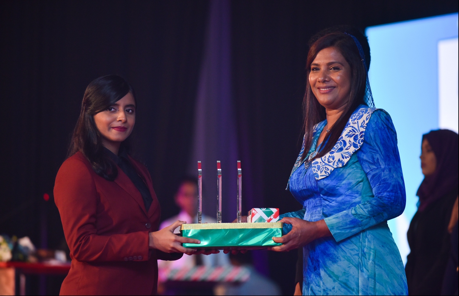 މާލެ: ޖުލައި 9، 2018- މިދިޔަ އަހަރުގެ އޮކްޓޯބަރު/ނޮވެމްބަރުގައި ބޭއްވި އޭ ލެވެލް އިމްތިހާނުގެ ރަންވަނަތައް ހޯދި ދަރިވަރުންނަށް އިނާމު ދިނުމަށް ދަރުބާރުގޭގައި ބޭއްވި ރަސްމިއްޔާތުގައި، އެޑިއުކޭޝަން މިނިސްޓަރު އާއިޝަތު ޝިހާމް، ދަރިވަރަކަށް އެވޯޑާއި އިނާމު ދެއްވަނީ.---ފޮޓޯ: ހުސެއިން ވަހީދު/މިހާރު