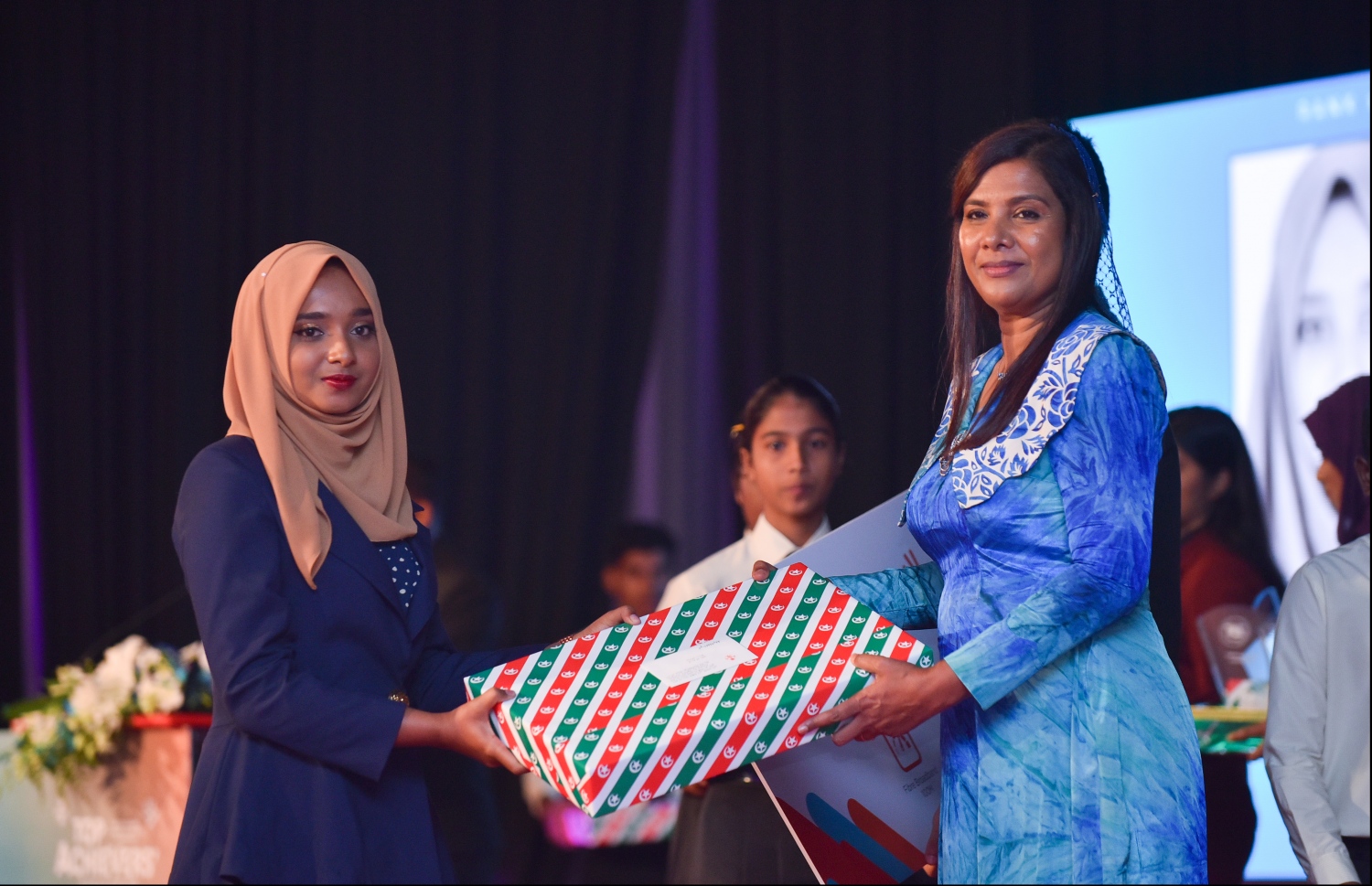 މާލެ: ޖުލައި 9، 2018- މިދިޔަ އަހަރުގެ އޮކްޓޯބަރު/ނޮވެމްބަރުގައި ބޭއްވި އޭ ލެވެލް އިމްތިހާނުގެ ރަންވަނަތައް ހޯދި ދަރިވަރުންނަށް އިނާމު ދިނުމަށް ދަރުބާރުގޭގައި ބޭއްވި ރަސްމިއްޔާތުގައި، އެޑިއުކޭޝަން މިނިސްޓަރު އާއިޝަތު ޝިހާމް، ދަރިވަރަކަށް އިނާމު ދެއްވަނީ.---ފޮޓޯ: ހުސެއިން ވަހީދު/މިހާރު