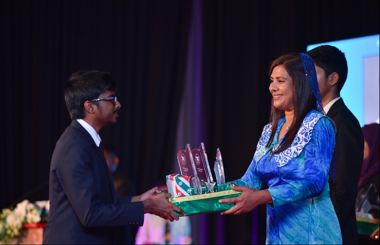 މާލެ: ޖުލައި 9، 2018- މިދިޔަ އަހަރުގެ އޮކްޓޯބަރު/ނޮވެމްބަރުގައި ބޭއްވި އޭ ލެވެލް އިމްތިހާނުގެ ރަންވަނަތައް ހޯދި ދަރިވަރުންނަށް އިނާމު ދިނުމަށް ދަރުބާރުގޭގައި ބޭއްވި ރަސްމިއްޔާތުގައި، އެޑިއުކޭޝަން މިނިސްޓަރު އާއިޝަތު ޝިހާމް، ދަރިވަރަކަށް އެވޯޑާއި އިނާމު ދެއްވަނީ.---ފޮޓޯ: ހުސެއިން ވަހީދު/މިހާރު