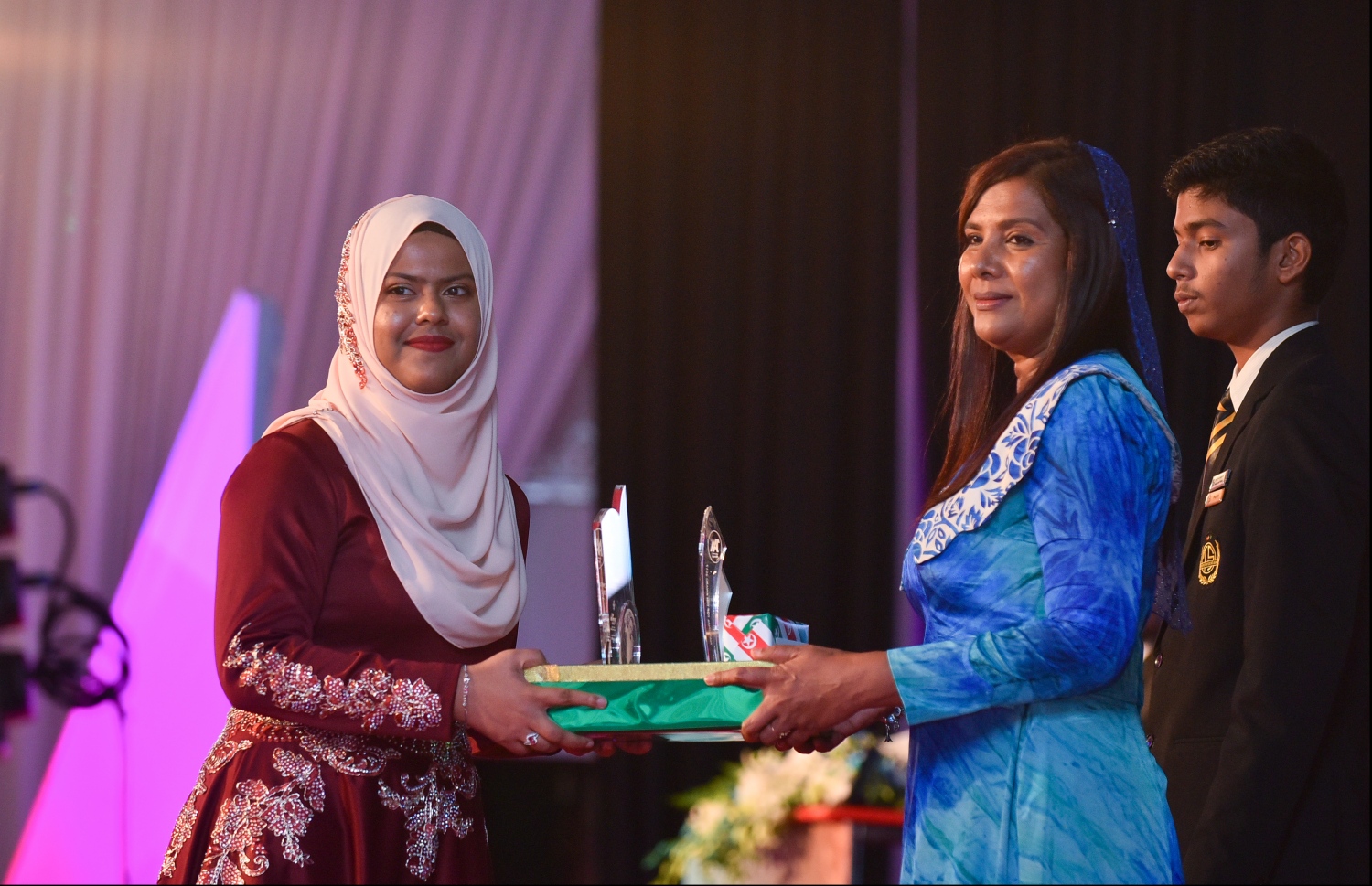 މާލެ: ޖުލައި 9، 2018- މިދިޔަ އަހަރުގެ އޮކްޓޯބަރު/ނޮވެމްބަރުގައި ބޭއްވި އޭ ލެވެލް އިމްތިހާނުގެ ރަންވަނަތައް ހޯދި ދަރިވަރުންނަށް އިނާމު ދިނުމަށް ދަރުބާރުގޭގައި ބޭއްވި ރަސްމިއްޔާތުގައި، އެޑިއުކޭޝަން މިނިސްޓަރު އާއިޝަތު ޝިހާމް، ދަރިވަރަކަށް އެވޯޑާއި އިނާމު ދެއްވަނީ.---ފޮޓޯ: ހުސެއިން ވަހީދު/މިހާރު