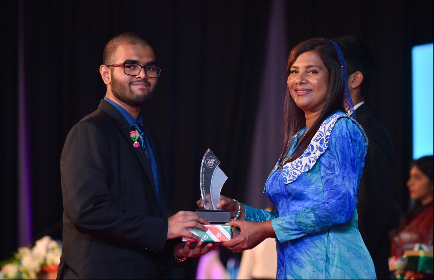 މާލެ: ޖުލައި 9، 2018- މިދިޔަ އަހަރުގެ އޮކްޓޯބަރު/ނޮވެމްބަރުގައި ބޭއްވި އޭ ލެވެލް އިމްތިހާނުގެ ރަންވަނަތައް ހޯދި ދަރިވަރުންނަށް އިނާމު ދިނުމަށް ދަރުބާރުގޭގައި ބޭއްވި ރަސްމިއްޔާތުގައި، އެޑިއުކޭޝަން މިނިސްޓަރު އާއިޝަތު ޝިހާމް، ދަރިވަރަކަށް އެވޯޑާއި އިނާމު ދެއްވަނީ.---ފޮޓޯ: ހުސެއިން ވަހީދު/މިހާރު