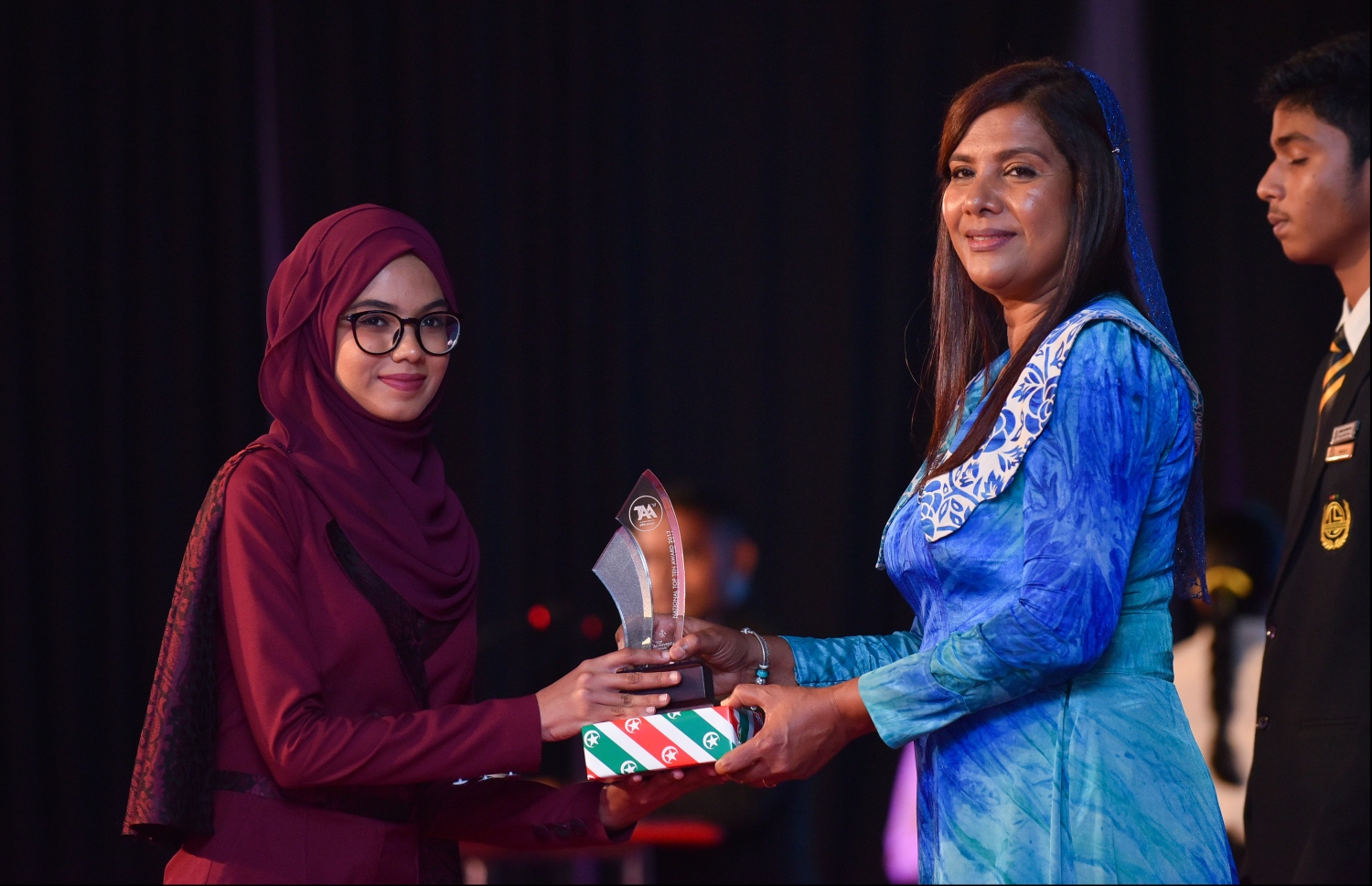 މާލެ: ޖުލައި 9، 2018: މިދިޔަ އަހަރުގެ އޮކްޓޯބަރު/ނޮވެމްބަރުގައި ބޭއްވި އޭ ލެވެލް އިމްތިހާނުން ވަނަތައް ހޯދި ދަރިވަރުންނަށް އެވޯޑު ދިނުމުގެގޮތުން ދަރުބާރުގޭގައި ބޭއްވި ރަސްމިއްޔާތުގައި އެޑިއުކޭޝަން މިނިސްޓަރު އައިޝަތު ޝިހާމު، ދަރިވަރަކަށް އެވޯޑު ހަވާލުކުރައްވަނީ.--- ފޮޓޯ: ހުސައިން ވަހީދު/މިހާރު