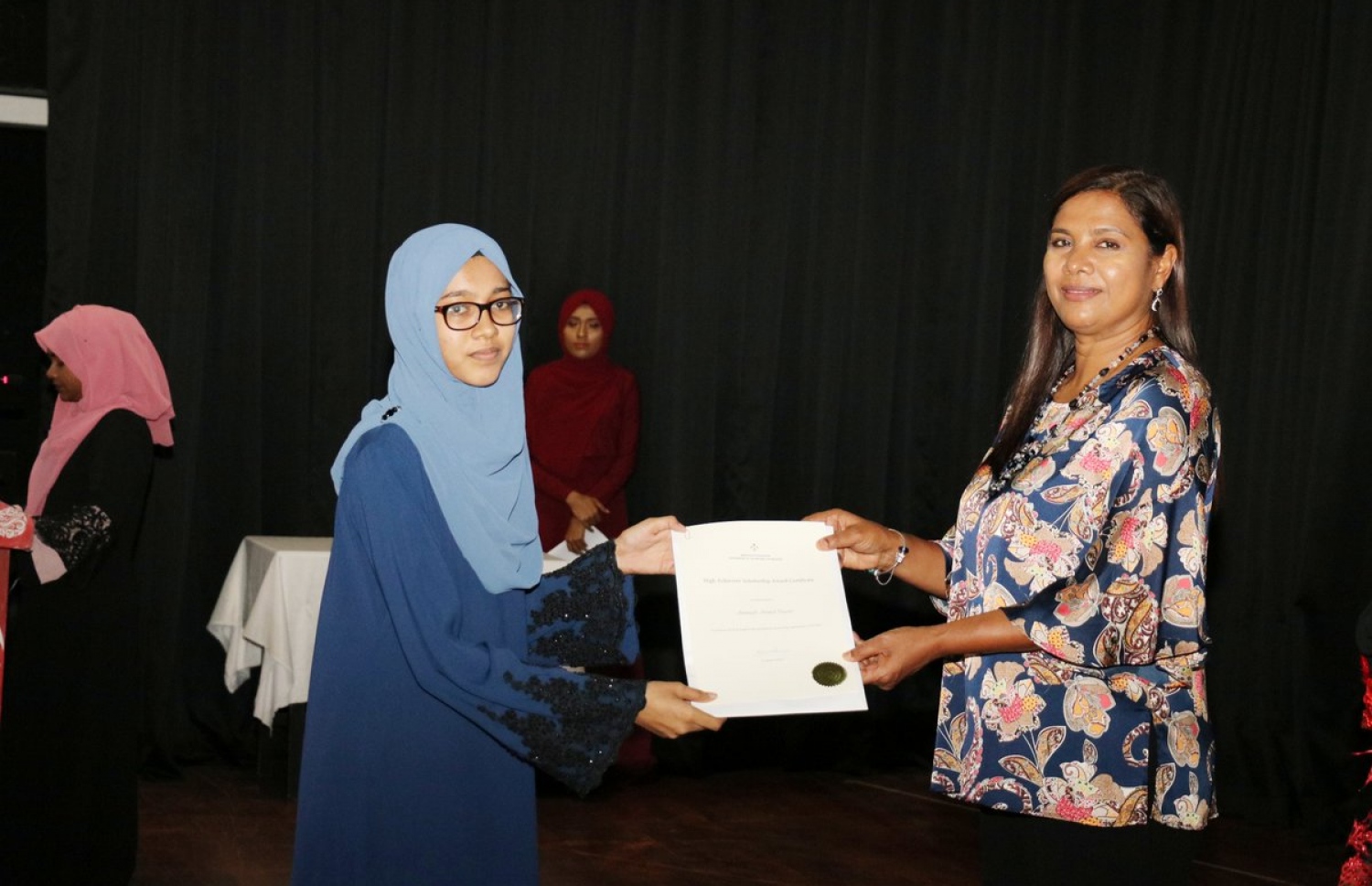 ހައި އެޗީވާސް ސްކޮލަޝިޕް ލިބުނު ދަރިވަރަކަށް، އެޑިއުކޭޝަން މިނިސްޓަރު ޑރ. އާއިޝަތު ޝިހާމް (ކ) މިރޭ ލިޔުން ހަވާލުކޮށްދެއްވަނީ.-- ފޮޓޯ: އެޑިއުކޭޝަން މިނިސްޓްރީ