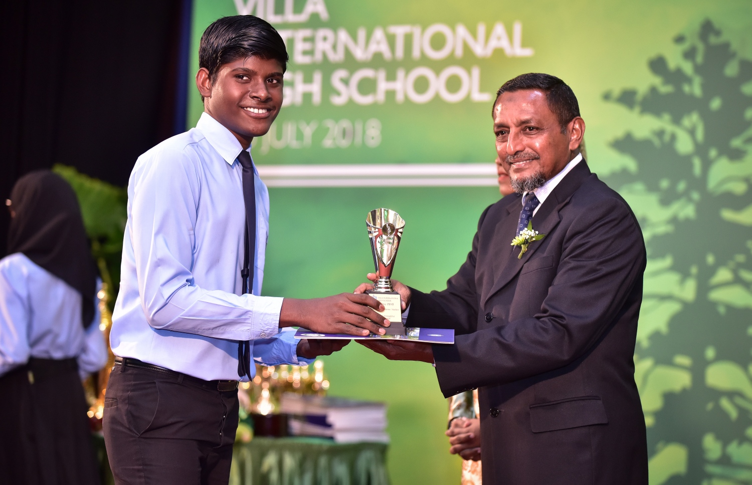 މާލެ: ޖުލައި 25، 2018: ވިލާ ހައި ސްކޫލުގެ މިދިޔަ އަހަރުގެ އިނާމު ދިނުމުގެ ޖަލްސާގައި، ވިލާ ފައުންޑޭޝަންގެ އެގްޒެކެޓިވް ޑިރެކްޓަރު މުހައްމަދު ހަމީދު، ދަރިވަރަކަށް އެވޯޑު ހަވާލުކޮށްދެއްވަނީ.--ފޮޓޯ: ނިޝާން އަލީ/މިހާރު