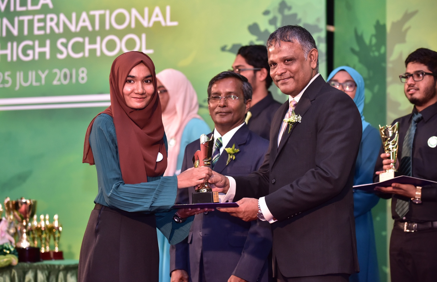 ވިލާ ހައި ސްކޫލުގެ މިދިޔަ އަހަރުގެ އިނާމު ދިނުމުގެ ޖަލްސާގައި، ވިލާ ކޮލެޖުގެ ކައުންސިލް މެމްބަރު ޑރ. ހަސަން، ދަރިވަރަކަށް އެވޯޑު ހަވާލުކޮށްދެއްވަނީ.-- ފޮޓޯ: ނިޝާން އަލީ/ މިހާރު