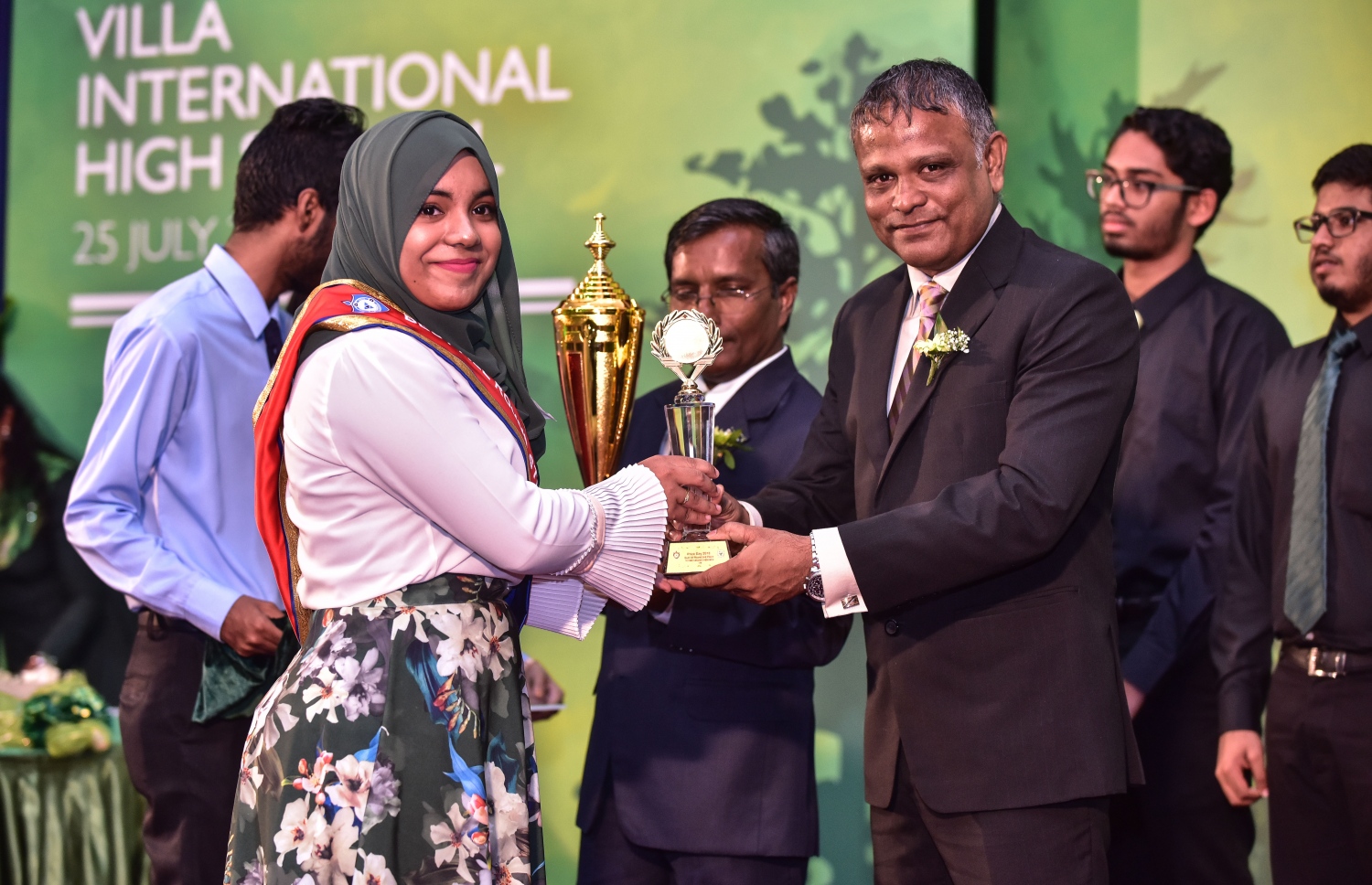 މާލެ: ޖުލައި 25، 2018: ވިލާ ހައި ސްކޫލުގެ މިދިޔަ އަހަރުގެ އިނާމު ދިނުމުގެ ޖަލްސާގައި، ވިލާ ކޮލެޖުގެ ކައުންސިލް މެމްބަރު ޑރ. ހަސަން، ދަރިވަރަކަށް އެވޯޑު ހަވާލުކޮށްދެއްވަނީ .--ފޮޓޯ: ނިޝާން އަލީ/މިހާރު