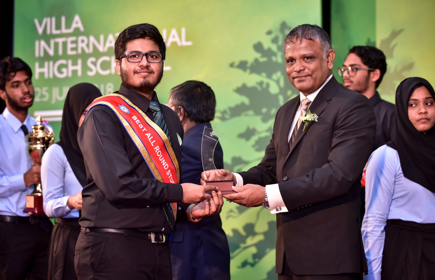 މާލެ: ޖުލައި 25، 2018: ވިލާ ހައި ސްކޫލުން މިދިޔަ އަހަރު އެންމެ މޮޅު ދަރިވަރުގެ މަގާމު ހޯދި ނާބިހަށް، ވިލާ ކޮލެޖުގެ ކައުންސިލް މެމްބަރު ޑރ. ހަސަން އިނާމު ހަވާލުކޮށްދެއްވަނީ .--ފޮޓޯ: ނިޝާން އަލީ/މިހާރު