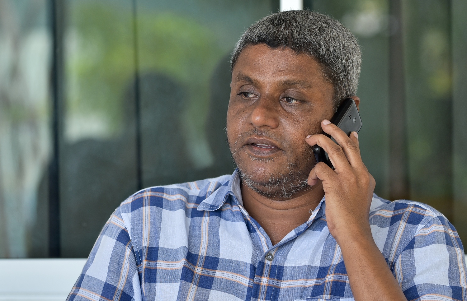 ޝާޒް، މޮބައިލް ފޯނުން މީހަކާ ވާހަކަ ދައްކަވަނީ.---ފޮޓޯ: ނިޝާން އަލީ/މިހާރު