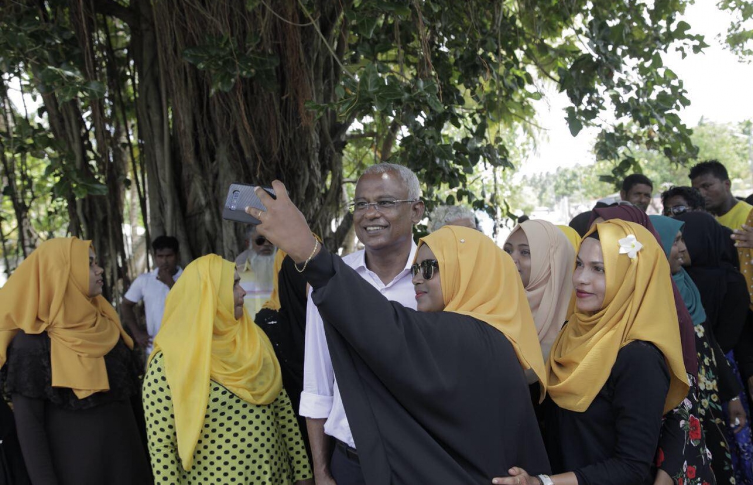 އިބޫ، ރާއްޖޭގެ ރަށަކަށް ކުރެއްވި ކެމްޕެއިން ދަތުރުފުޅެއްގައި، އެމްޑީޕީގެ ސަޕޯޓަރުންނާ އެކު ސެލްފީއެއް ނަންގަވަނީ. - ފޮޓޯ: އެމްޑީޕީ