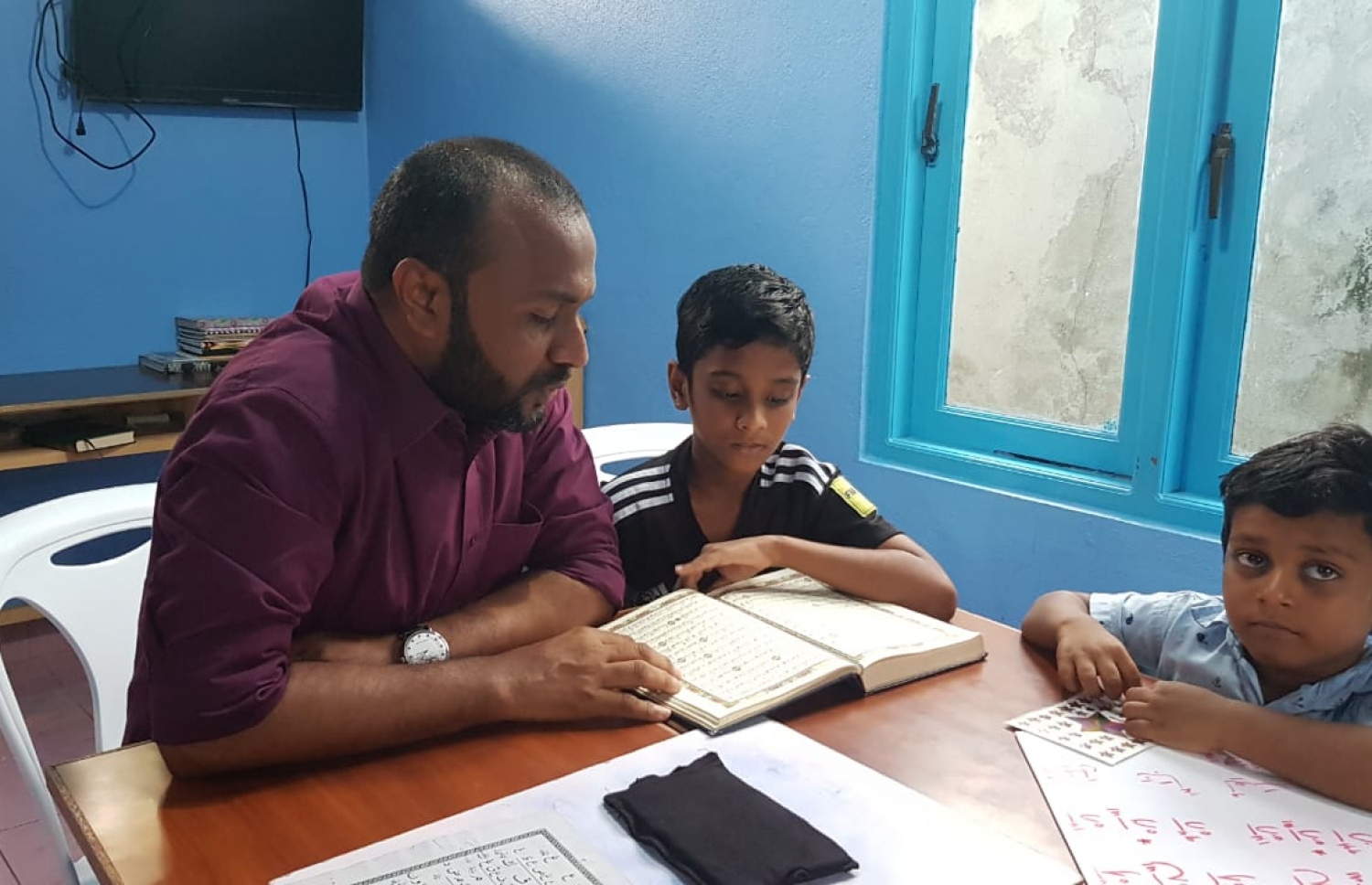 މި އަހަރުގެ ރިޔާސީ އިންތިޚާބުގައި ވާދަކުރައްވާ ޕީޕީއެމްގެ ކެންޑިޑޭޓް ރައީސް ޔާމީންގެ ރަނިންމޭޓް ޑރ. ޝަހީމް ފުވައްމުލަކަށް ކުރައްވާ ކެމްޕެއިން ދަތުރުގެ ތެރެއިން، ކުޑަކުއްޖަކަށް ގުރުއާން ކިޔަވައި ދެއްވަނީ.---ފޮޓޯ: ޕީޕީއެމް