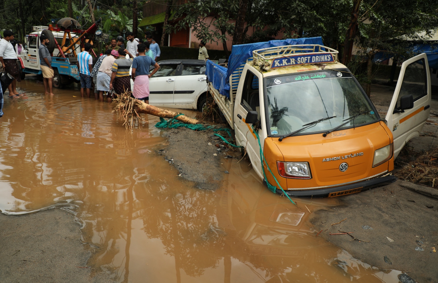 ކެރާލާގެ ފެންބޮޑުވުމުގައި ކިސަޑުގެ ތެރޭގައި ތާށިވެފައިވާ ކާރެއްގެ ކައިރީ ބަޔަކު ހަރަކާތްތެރި ވަނީ. --ފޮޓޯ:އޭއެފްޕީ