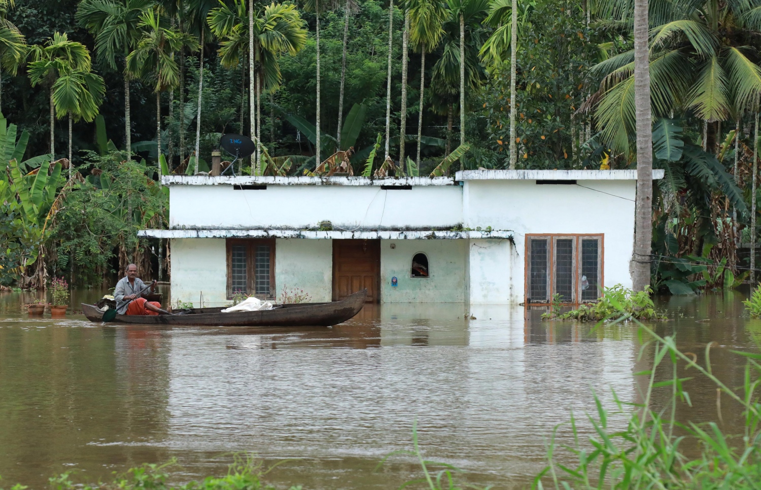 ކެރަލާ ސްޓޭޓުގެ ކޮޗިންގައި ފެންބޮޑުވެފައިވާ ސަރަހައްދުގައި ކުޑަ ޑިންގީއެއް މީހަކު ދުއްވަނީ. --ފޮޓޯ:އޭއެފްޕީ