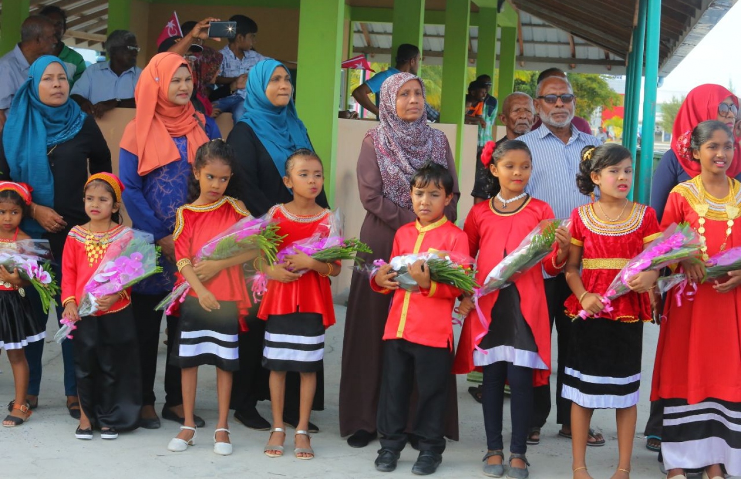 ގދ.ތިނަދޫ: އޮގަސްޓް 16، 2018- މި އަހަރުގެ ރިޔާސީ އިންތިޚާބުގައި ވާދަކުރައްވާ ޕީޕީއެމްގެ ކެންޑިޑޭޓް ރައީސް ޔާމީންގެ ރަނިންމޭޓް ޝަހީމް ކެމްޕެއިނަށް ތިނަދު އަށް ވަޑައިގަތުމުން، އޭނާ އަށް މާބޮނޑި އެރުވުމަށް ދިވެހި ސަގާފީ ހެދުމުގައި ތިބި ކުޑަކުދިންތަކެއް.---ފޮޓޯ: ޕީޕީއެމް