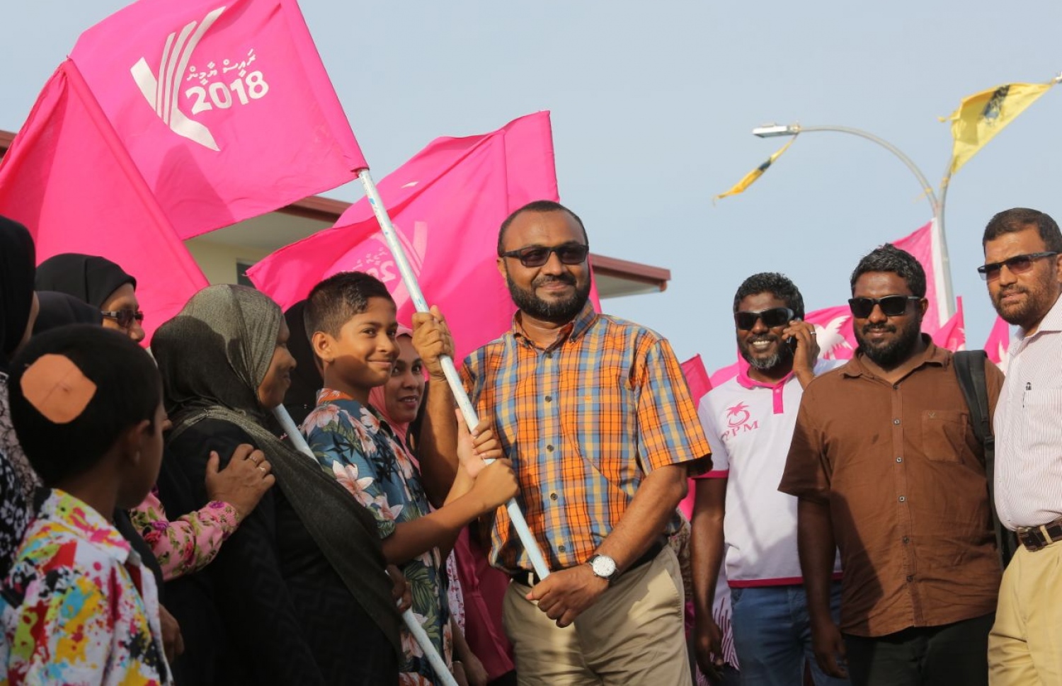 ގދ.ތިނަދޫ: އޮގަސްޓް 16، 2018- މި އަހަރުގެ ރިޔާސީ އިންތިޚާބުގައި ވާދަކުރައްވާ ޕީޕީއެމްގެ ކެންޑިޑޭޓް ރައީސް ޔާމީންގެ ރަނިންމޭޓް ޝަހީމް ކެމްޕެއިނަށް ތިނަދު އަށް ވަޑައިގަތުމުން، މަރުހަބާ ކިޔަން އެއްވި މީހުންގެ ތެރެއިން، ކުޑަކުއްޖަކު ހިފައިގެން ހުރި "ރައީސް ޔާމީން 2018" ޖަހާފައިވާ ދިދައެއްގައި ޝަހީމް ވެސް ހިއްޕަވައިގެން ފޮޓޯއެއް ނަންގަވަނީ.---ފޮޓޯ: ޕީޕީއެމް