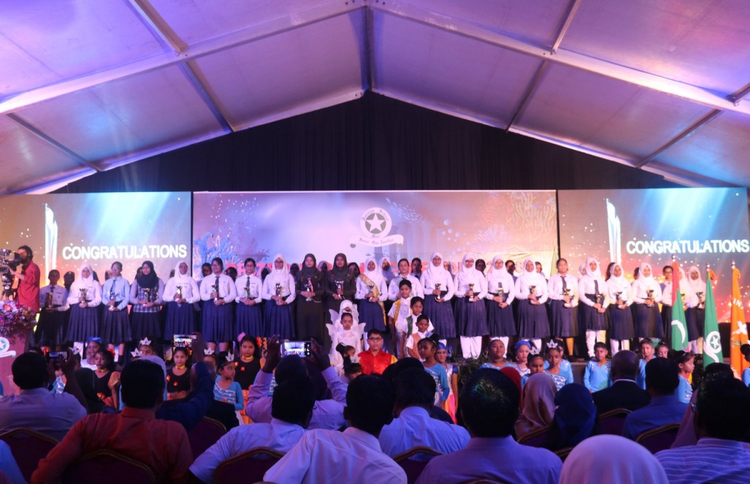 އަމީނިއްޔާ ސްކޫލުގެ މިދިޔަ އަހަރުގެ އިނާމު ދިނުމުގެ ރަސްމިއްޔާތުގައި، އިނާމު ހޯދި ދަރިވަރުން ރޭ ފޮޓޯއަކަށް ހުއްޓިގެން.-- ފޮޓޯ: އެޑިއުކޭޝަން މިނިސްޓްރީ