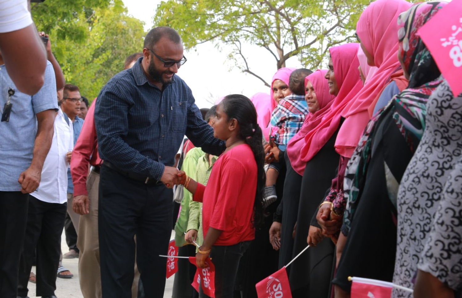 ލ. ކައްދޫ: އޮގަސްޓް 24، 2018- މި އަހަރުގެ ރިޔާސީ އިންތިޚާބުގެ ކެމްޕެއިނަށް، ޕީޕީއެމްގެ ކެންޑިޑޭޓް ރައީސް އަބްދުﷲ ޔާމީންގެ ރަނިންމޭޓް ޑރ. މުހައްމަދު ޝަހީމް އަލީ ސައީދު ލ. އަތޮޅަށް ވަޑައިގަތުމުން ކައްދޫ އެއާޕޯޓުން އޭނާ އަށް މަރުހަބާ ކިޔުމަށް ދިޔަ މީހުންގެ ތެރެއިން ކުޑަކުއްޖަކާ ސަލާމް ކުރައްވަނީ.---ފޮޓޯ: ޕީޕީއެމް