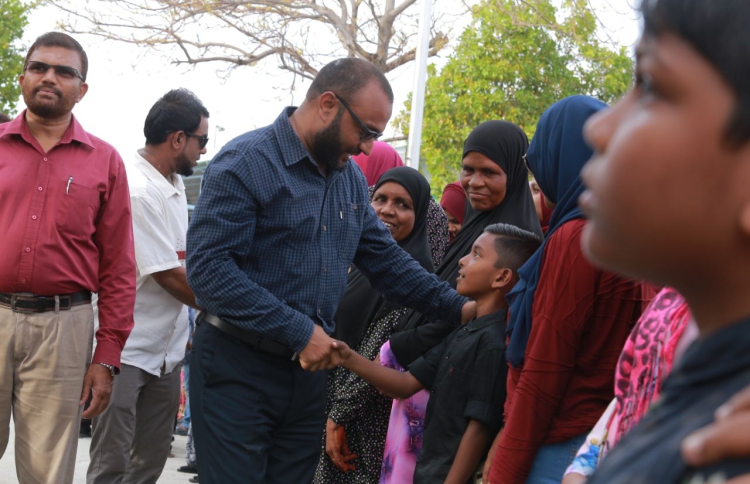 ލ. ކައްދޫ: އޮގަސްޓް 24، 2018- މި އަހަރުގެ ރިޔާސީ އިންތިޚާބުގެ ކެމްޕެއިނަށް، ޕީޕީއެމްގެ ކެންޑިޑޭޓް ރައީސް އަބްދުﷲ ޔާމީންގެ ރަނިންމޭޓް ޑރ. މުހައްމަދު ޝަހީމް އަލީ ސައީދު ލ. އަތޮޅަށް ވަޑައިގަތުމުން ކައްދޫ އެއާޕޯޓުން އޭނާ އަށް މަރުހަބާ ކިޔުމަށް ދިޔަ މީހުންގެ ތެރެއިން ކުޑަކުއްޖަކާ ސަލާމް ކުރައްވަނީ.---ފޮޓޯ: ޕީޕީއެމް