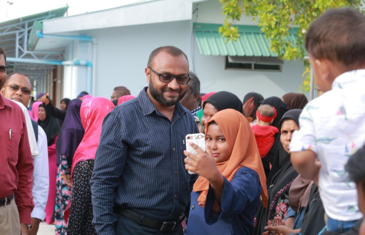 ލ. ކައްދޫ: އޮގަސްޓް 24، 2018- މި އަހަރުގެ ރިޔާސީ އިންތިޚާބުގެ ކެމްޕެއިނަށް، ޕީޕީއެމްގެ ކެންޑިޑޭޓް ރައީސް އަބްދުﷲ ޔާމީންގެ ރަނިންމޭޓް ޑރ. މުހައްމަދު ޝަހީމް އަލީ ސައީދު ލ. އަތޮޅަށް ވަޑައިގަތުމުން ކައްދޫ އެއާޕޯޓުން އޭނާ އަށް މަރުހަބާ ކިޔަން ދިޔަ ކުޑަކުއްޖަކާ އެކު ސެލްފީއެއް ނަންގަވަނީ.---ފޮޓޯ: ޕީޕީއެމް