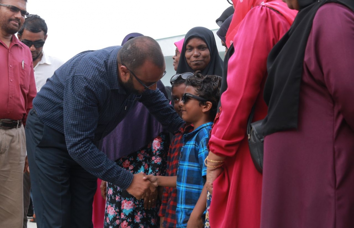 ލ. ކައްދޫ: އޮގަސްޓް 24، 2018- މި އަހަރުގެ ރިޔާސީ އިންތިޚާބުގެ ކެމްޕެއިނަށް، ޕީޕީއެމްގެ ކެންޑިޑޭޓް ރައީސް އަބްދުﷲ ޔާމީންގެ ރަނިންމޭޓް ޑރ. މުހައްމަދު ޝަހީމް އަލީ ސައީދު ލ. އަތޮޅަށް ވަޑައިގަތުމުން ކައްދޫ އެއާޕޯޓުން އޭނާ އަށް މަރުހަބާ ކިޔުމަށް ދިޔަ މީހުންގެ ތެރެއިން ކުޑަކުއްޖަކާ ސަލާމް ކުރައްވަނީ.---ފޮޓޯ: ޕީޕީއެމް