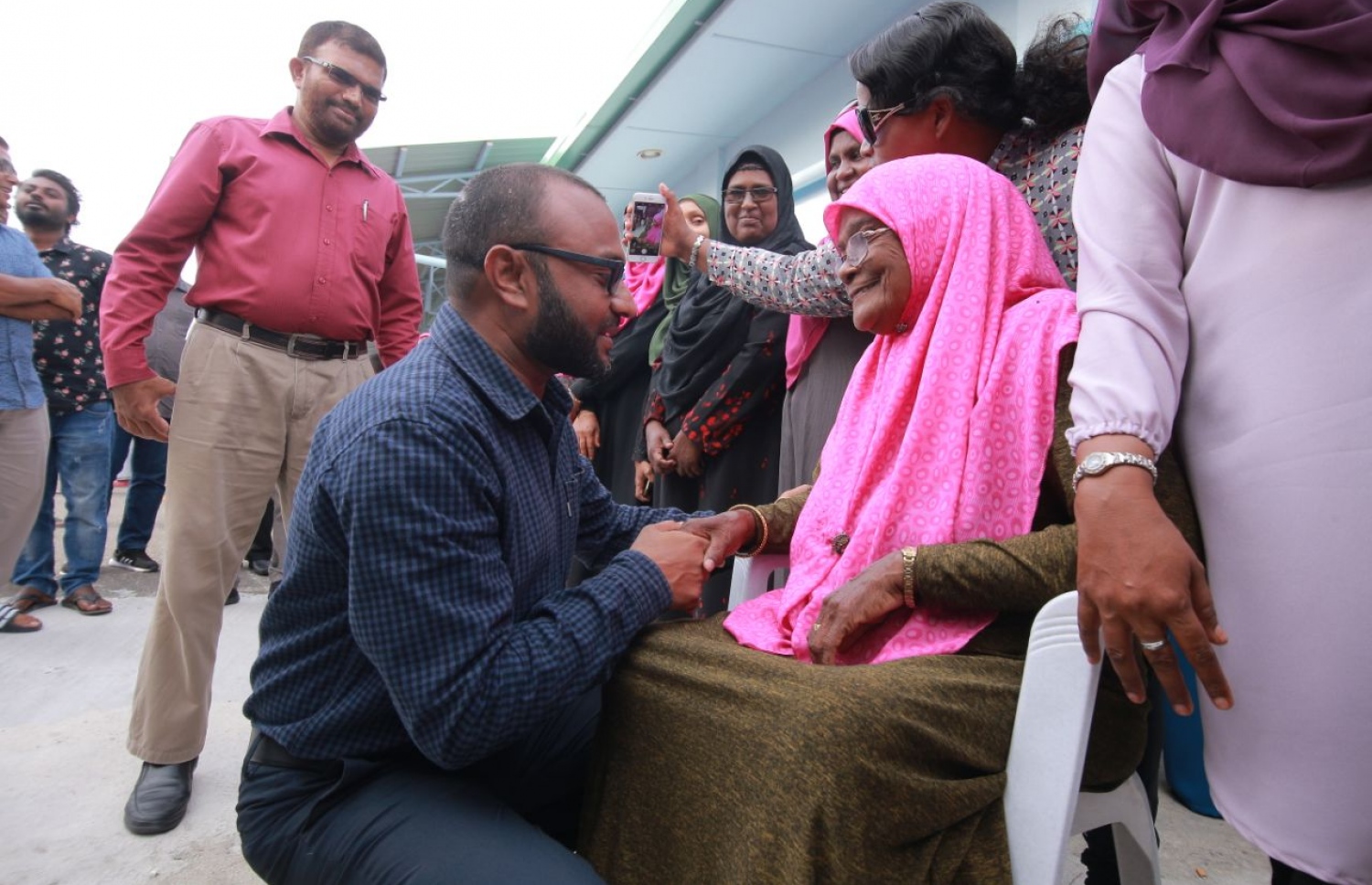 ލ. ކައްދޫ: އޮގަސްޓް 24، 2018- މި އަހަރުގެ ރިޔާސީ އިންތިޚާބުގެ ކެމްޕެއިނަށް، ޕީޕީއެމްގެ ކެންޑިޑޭޓް ރައީސް އަބްދުﷲ ޔާމީންގެ ރަނިންމޭޓް ޑރ. މުހައްމަދު ޝަހީމް އަލީ ސައީދު ލ. އަތޮޅަށް ވަޑައިގަތުމުން ކައްދޫ އެއާޕޯޓުން އޭނާ އަށް މަރުހަބާ ކިޔަން ދިޔަ، އުމުރުން ދުވަސްވީ މީހަކާ ވާހަކަ ދައްކަވަނީ.---ފޮޓޯ: ޕީޕީއެމް