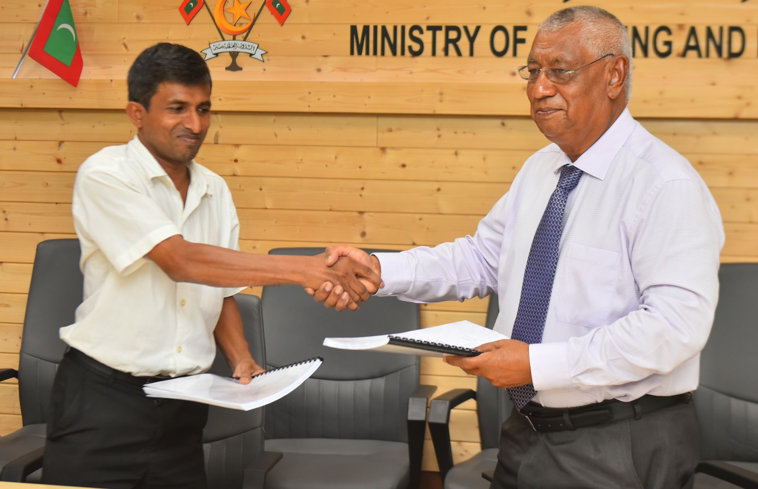 ހައުސިން މިނިސްޓްރީގެ ސްޓޭޓް މިނިސްޓަރު މުހައްމަދު އިބްރާހީމް (ކ)، އަދި އިނާ ޓްރޭޑިންގް ކޮމްޕެނީގެ މެނޭޖިންގް ޑައިރެކްޓަރު އަހްމަދް އާރިފް އެއްބަސްވުން ބަދަލުކުރަނީ. -- ފޮޓޯ: އަހްމަދު ނިޝާތު/މިހާރު