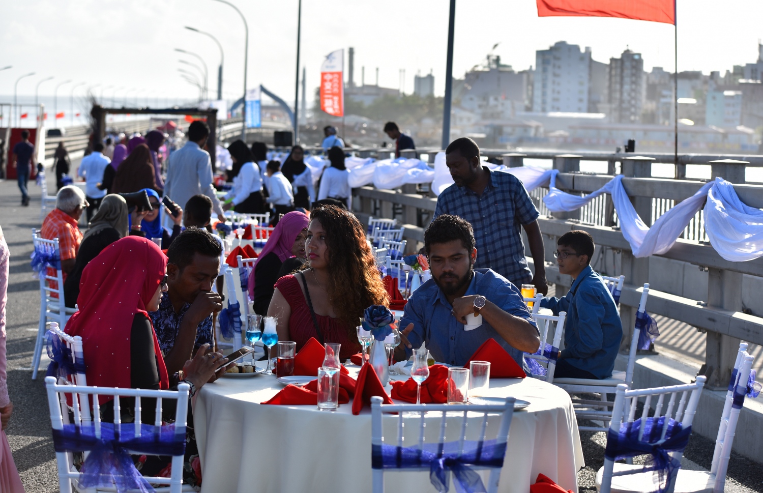 އޮގަސްޓް 31، 2018- މާލެ-ހުޅުލެ ބްރިޖުމަތީގައި މިއަދު ހަވީރު ކައިވެނި ކުރުމަށްޓަކައި ޒީނަތްތެރި ކޮށްފައިވާ ސަރަހައްދުގައި ބައެއް އާއިލާތައް މަޑުކޮށްލައިގެން.--- ފޮޓޯ: އަހުމަދު ނިޝާތު/މިހާރު