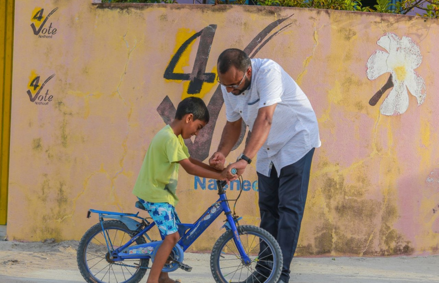 ހދ. ހަނިމާދޫ: ސެޕްޓެމްބަރު 1، 2018: މިމަހު 23 ގައި ބާއްވާ މި އަހަރުގެ ރިޔާސީ އިންތިޚާބުގެ ކެމްޕެއިނަށް، ޕީޕީއެމްގެ ކެންޑިޑޭޓް ރައީސް އަބްދުﷲ ޔާމީންގެ ރަނިންމޭޓް ޑރ. މުހައްމަދު ޝަހީމް އަލީ ސައީދު ހދ. ހަނިމާދޫއަށް ކުރެއްވި ކެމްޕެއިން ދަތުރުގައި، އެރަށުެ މަގެއްގެ މަތީގައި ބައިސިކަލު ދުއްވަން އުޅުނު ކުޑަކުއްޖަކާ ވާހަކަދައްކަވާލައްވަނީ--. ފޮޓޯ:ޕީޕީއެމް