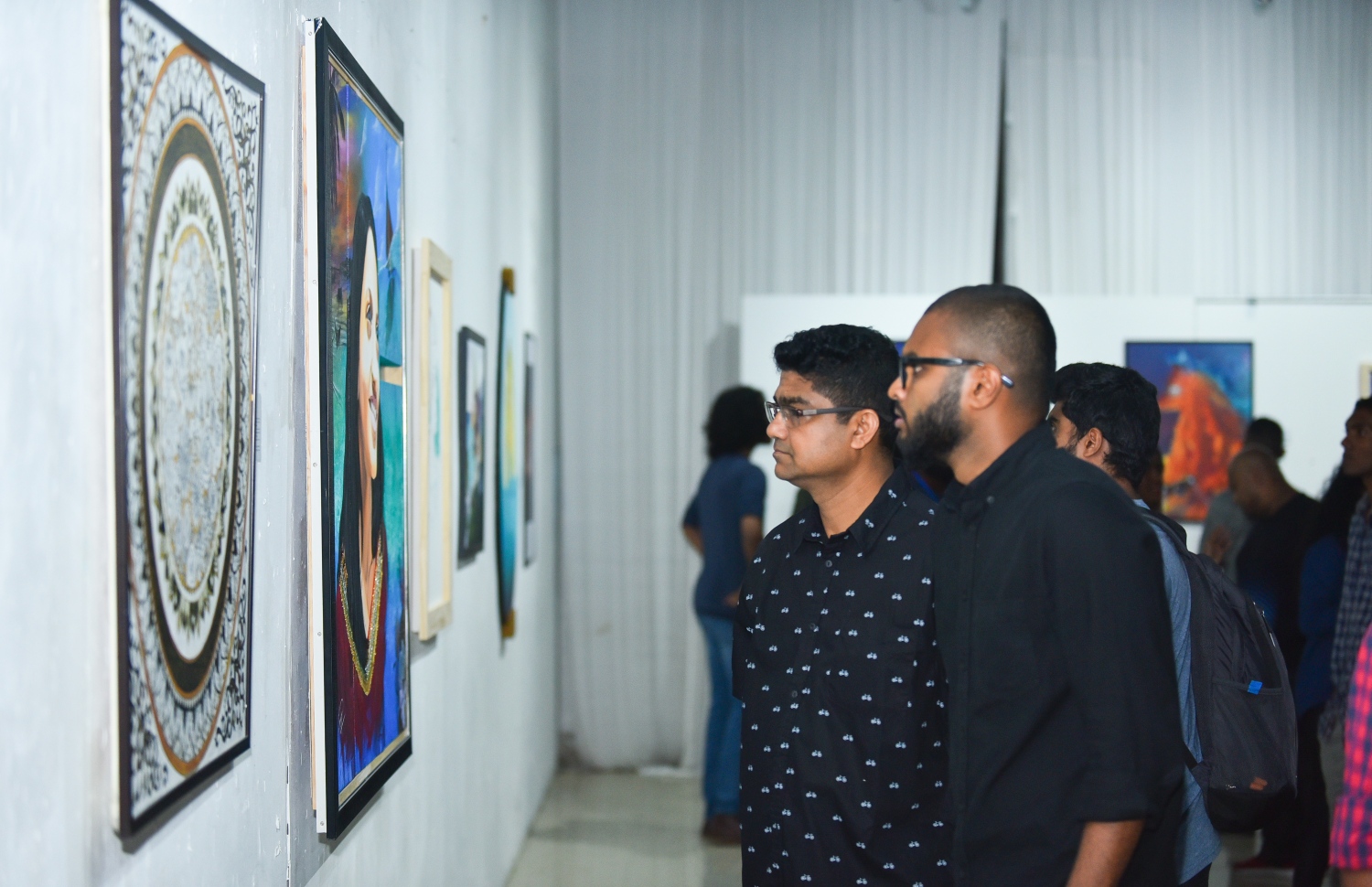 ސެޕްޓެމްބަރު 3، 2018- "މޯލްޑިވްސް ކޮންޓެންޕޮރަރީ އާޓް އެގްޒިބިޝަން 2018" ގައި ބަހައްޓާފައިވާ ކުރެހުންތަކެއް ދެ މީހަކު ބަލަނީ: އަންނަ ހުކުރު ދުވަހުގެ ނިޔަލަށް ކުރިއަށް ގެންދާ މި މައުރަޒުގެ ފުރަތަމަ ރޭ ވެސް ވަނީ ވަރަށް ކުރެހުންތައް ވިކިފައި.--- ފޮޓޯ: ހުސައިން ވަހީދު/މިހާރު