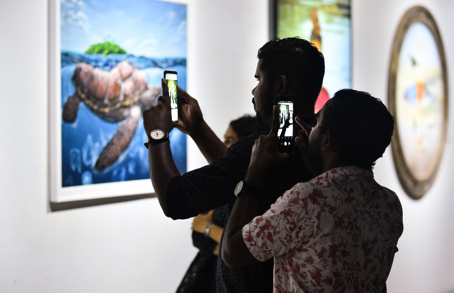 ސެޕްޓެމްބަރު 3، 2018- "މޯލްޑިވްސް ކޮންޓެންޕޮރަރީ އާޓް އެގްޒިބިޝަން 2018" ގައި ބަހައްޓާފައިވާ ކުރެހުމެއްގެ ފޮޓޯ ދެ މީހަކު ނަގަނީ.--- ފޮޓޯ: ހުސައިން ވަހީދު/މިހާރު