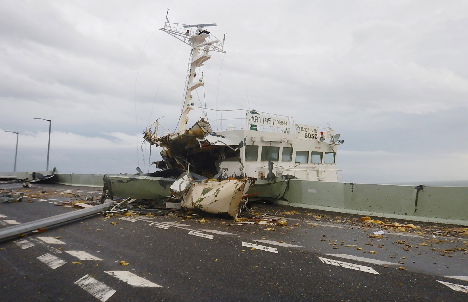 ޖަޕާން- ސެޕްޓެމްބަރު 5، 2018: ޖަޕާނަށް އެރި ބާރުގަދަ ތޫފާނުގައި އޮސާކާ އެއާޕޯޓަށް ދާން އޮންނަ ބްރިޖުގައި ޓޭންކަރަކުން ޖެހި ގެއްލުންތައް ލިބިފައި. --ފޮޓޯ:އޭއެފްޕީ