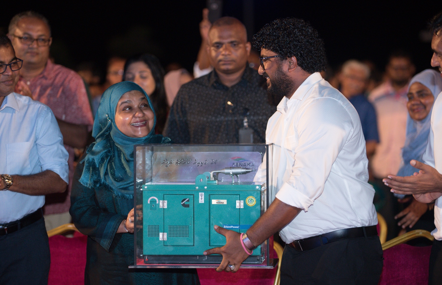 މާލެ: ސެޕްޓެމްބަރު 6، 2018- ޗައިނާ ސަރުކާރުން ރާއްޖެ އަށް 35 ޖަނަރޭޓަރު ހަދިޔާކުރުން ފާހަގަކުރުމުގެ ގޮތުން ޖުމްހޫރީ މައިދާނުގައި "24 ގަޑިއިރު ކަރަންޓު ޔަގީން" ގެ ނަމުގައި ބޭއްވި ޖަލްސާގައި ފެނަކަ ކޯޕަރޭޝަންގެ މެނޭޖިން ޑިރެކްޓަރު ލަމްއާން، ރައީސް ޔާމީންގެ އަނބިކަނބަލުން ފާތިމަތު އިބްރާހިމްއަށް ހަދިޔާއެއް އަރުވަނީ.---ފޮޓޯ: ހުސައިން ވަހީދު/މިހާރު