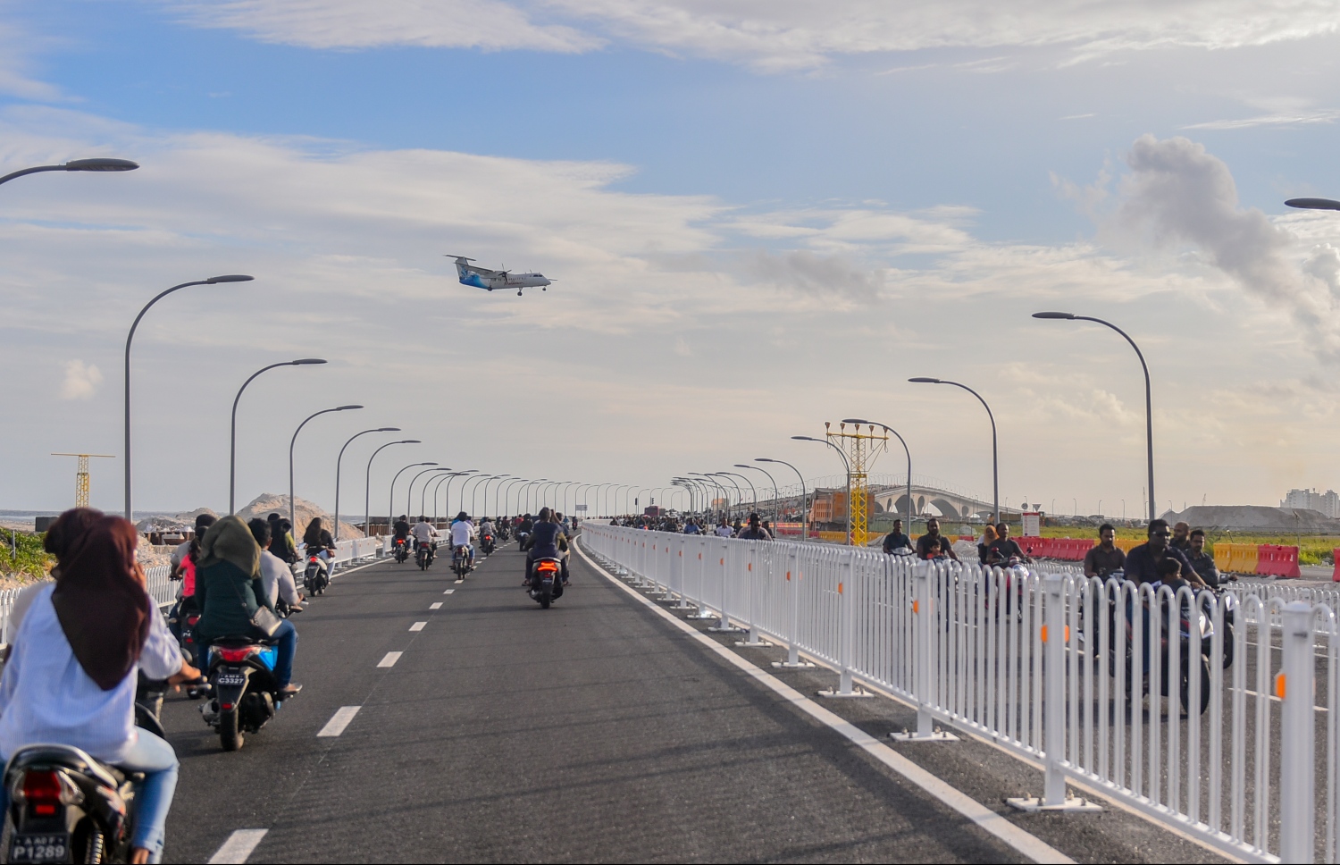 ސެޕްޓެމްބަރު 7، 2018- ސިނަމާލެ ބްރިޖު، އާންމު ދަތުރުފަތުރަށް މިއަދު ހުޅުވައިލުމާ އެކު ބަޔަކު އެ ބްރިޖުމަތިން ސައިކަލްތަކުގައި ދުއްވާފައި ދާއިރު، މޯލްޑިވިއަންގެ މަތިންދާބޯޓެއް ވެލާނާ އިންޓަނޭޝަނަލް އެއާޕޯޓަށް ޖައްސަން ދަނީ.---ފޮޓޯ: އަހުމަދު ނިޝާތު/މިހާރު