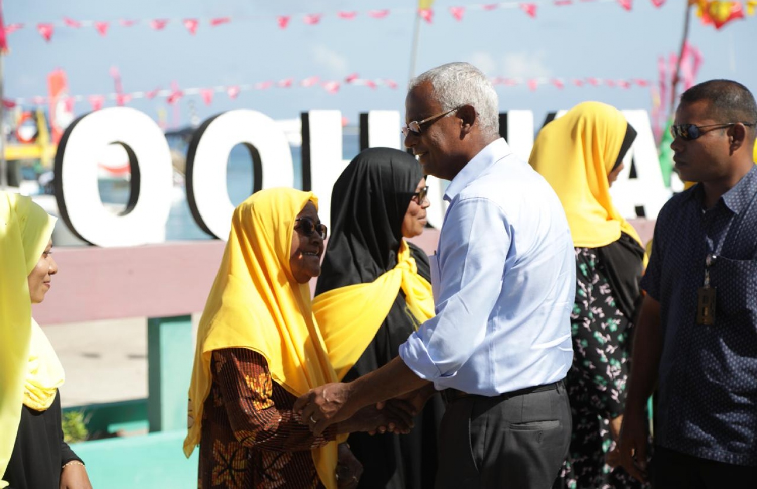 އިބޫ މިއަދު ލަންދު އަށް ވަޑައިގެން އެ ރަށުގައި ދިރިއުޅޭ އަންހެނަކާ ސަލާމް ކުރައްވަނީ. - ފޮޓޯ: އެމްޑީޕީ