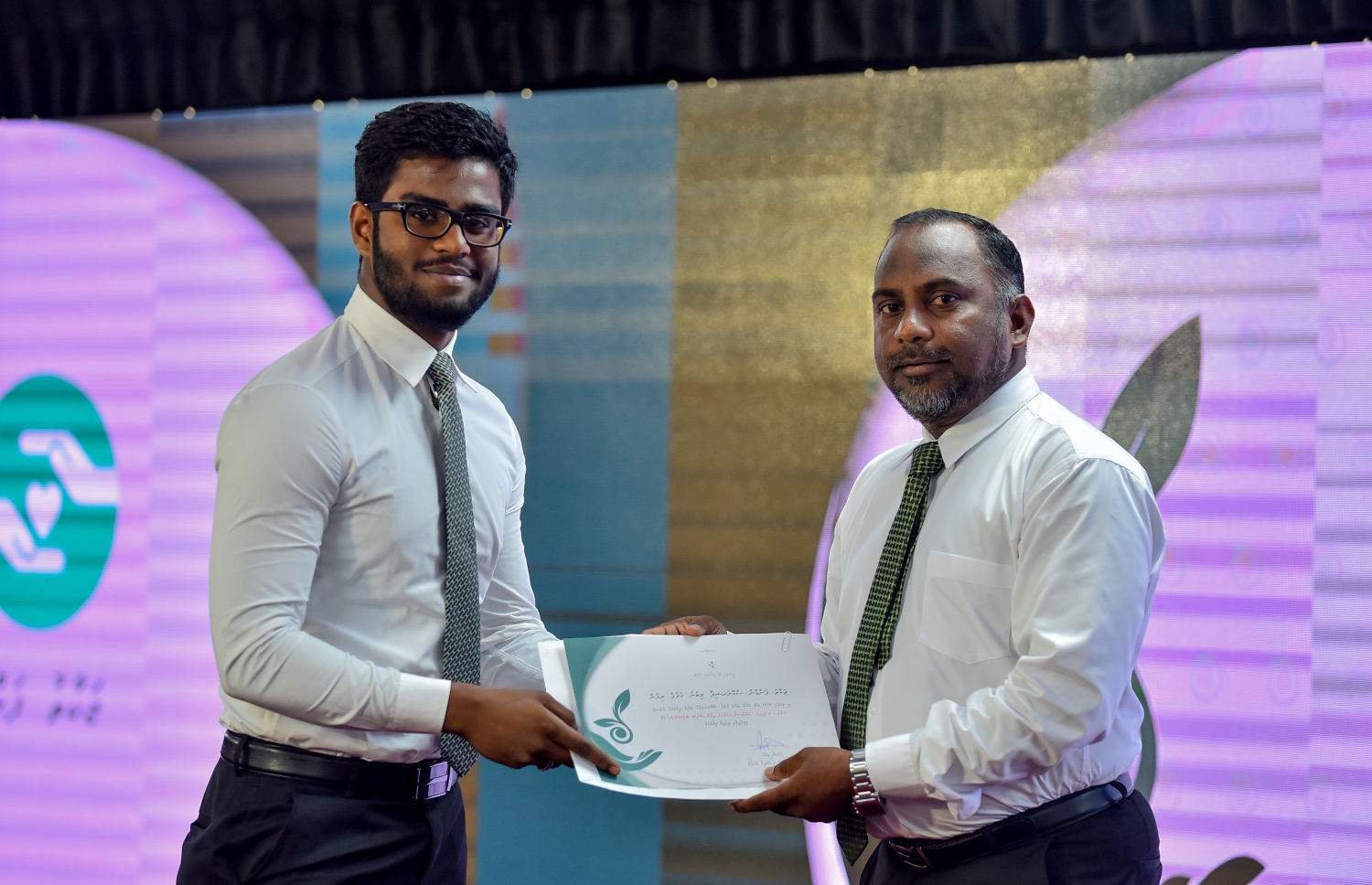 މާލެ: ސެޕްޓެމްބަރު 10، 2018: ޒަކާތު ފަންޑުގެ އެހީގައި ދޭ ސްކޮލަޝިޕްގެ ލިޔުން ހަވާލުކުރުމަށް އިސްލާމީ މަރުކަޒުގައި ބޭއްވި ހާއްސަ ރަސްމިއްޔާތުގައި ސްކޮލަޝިޕް ލިބުނު ދަރިވަރަކަށް، އިސްލާމިކް މިނިސްޓަރު ޑރ. ޒިޔާދު ބާގިރް(ކ) ލިޔުން ހަވާލުކޮށްދެއްވަނީ.-- ފޮޓޯ: އަހުމަދު ނިޝާތު /މިހާރު