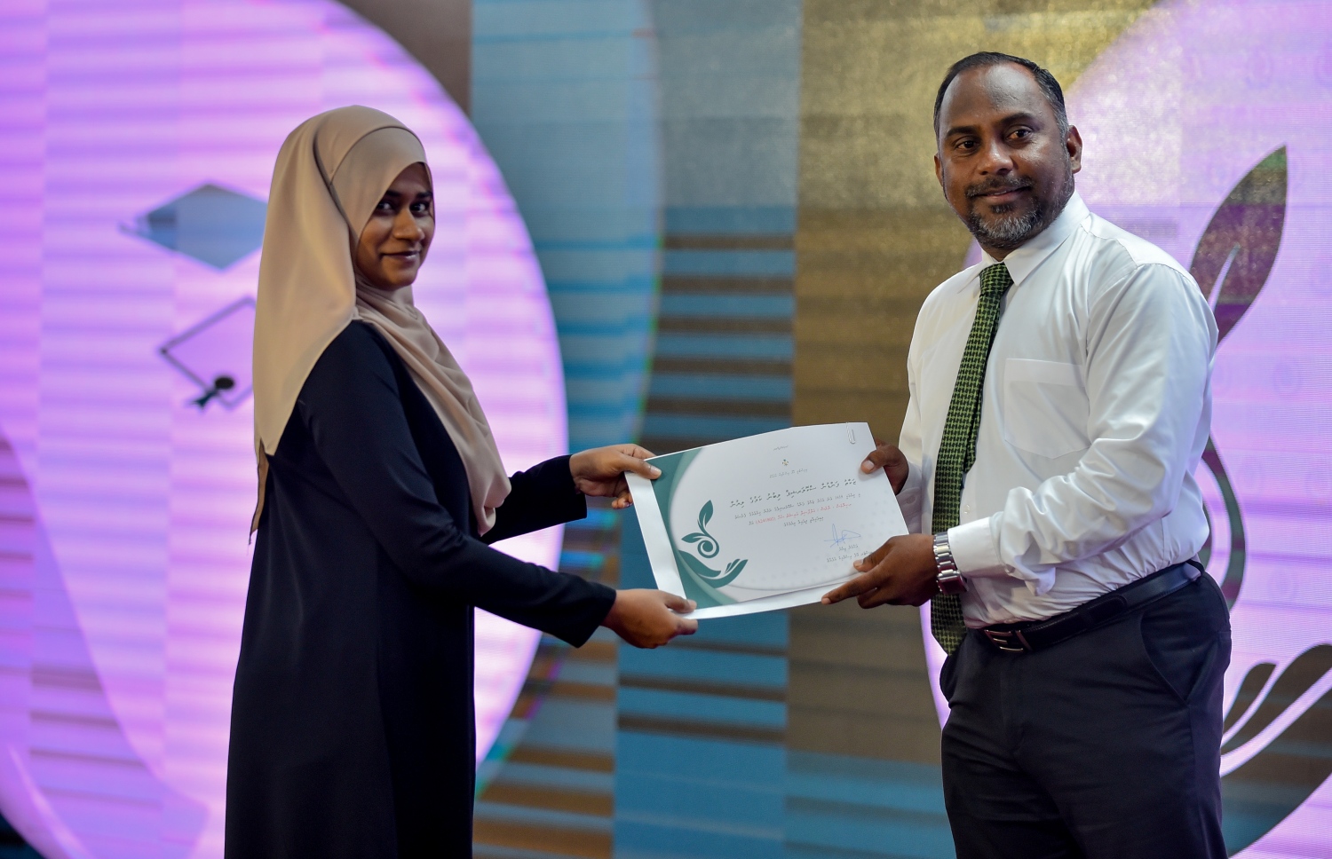 މާލެ: ސެޕްޓެމްބަރު 10، 2018: ޒަކާތު ފަންޑުގެ އެހީގައި ދޭ ސްކޮލަޝިޕްގެ ލިޔުން ހަވާލުކުރުމަށް އިސްލާމީ މަރުކަޒުގައި ބޭއްވި ހާއްސަ ރަސްމިއްޔާތުގައި ސްކޮލަޝިޕް ލިބުނު ދަރިވަރަކަށް، އިސްލާމިކް މިނިސްޓަރު ޑރ. ޒިޔާދު ބާގިރް(ކ) ލިޔުން ހަވާލުކޮށްދެއްވަނީ.-- ފޮޓޯ: އަހުމަދު ނިޝާތު /މިހާރު