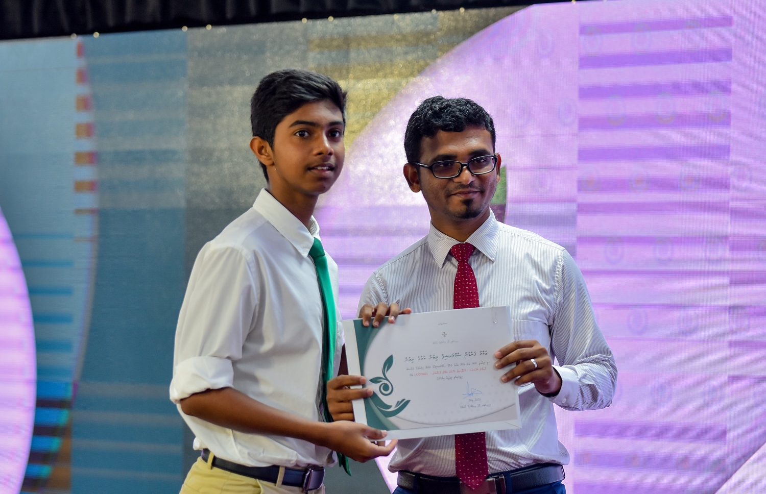 މާލެ: ސެޕްޓެމްބަރު 10، 2018: ޒަކާތު ފަންޑުގެ އެހީގައި ދޭ ސްކޮލަޝިޕްގެ ލިޔުން ހަވާލުކުރުމަށް އިސްލާމީ މަރުކަޒުގައި ބޭއްވި ހާއްސަ ރަސްމިއްޔާތުގައި ސްކޮލަޝިޕް ލިބުނު ދަރިވަރަކަށް، ފިނޭންސް މިނިސްޓަރު އަހުމަދު މުނައްވަރު(ކ) ލިޔުން ހަވާލުކޮށްދެއްވަނީ.-- ފޮޓޯ: އަހުމަދު ނިޝާތު /މިހާރު