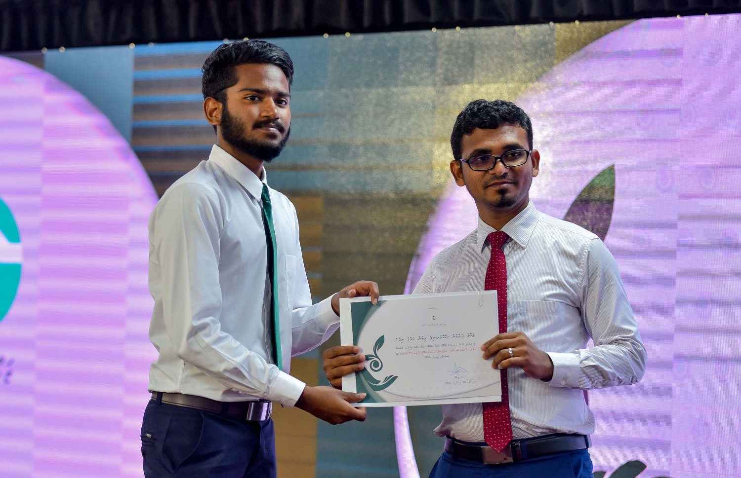 މާލެ: ސެޕްޓެމްބަރު 10، 2018: ޒަކާތު ފަންޑުގެ އެހީގައި ދޭ ސްކޮލަޝިޕްގެ ލިޔުން ހަވާލުކުރުމަށް އިސްލާމީ މަރުކަޒުގައި ބޭއްވި ހާއްސަ ރަސްމިއްޔާތުގައި ސްކޮލަޝިޕް ލިބުނު ދަރިވަރަކަށް، ފިނޭންސް މިނިސްޓަރު އަހުމަދު މުނައްވަރު(ކ) ލިޔުން ހަވާލުކޮށްދެއްވަނީ.-- ފޮޓޯ: އަހުމަދު ނިޝާތު /މިހާރު