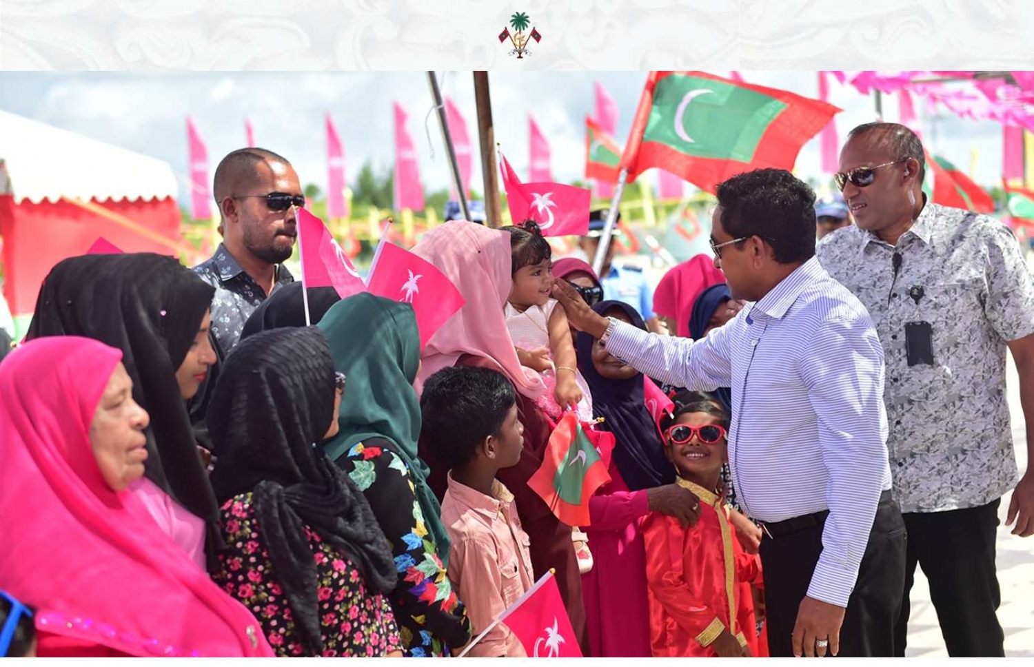 ގދ. ތިނަދޫ: ސެޕްޓެމްބަރު 11، 2018- ރައީސް އަބްދުﷲ ޔާމީން ތިނަދުއަށް ވަޑައިގަތުމުން، މަރުހަބާ ދަންނަވަން ދިޔަ މީހުންގެ ތެރެއިން ކުޑަކުއްޖެއްގެ ކޮލުގައި ފިރުމާލައްވަނީ.---ފޮޓޯ: ރައީސް އޮފީސް